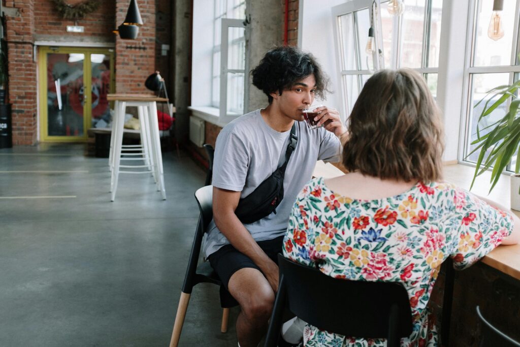 Young adults enjoy a relaxed conversation and coffee in a stylish urban café.