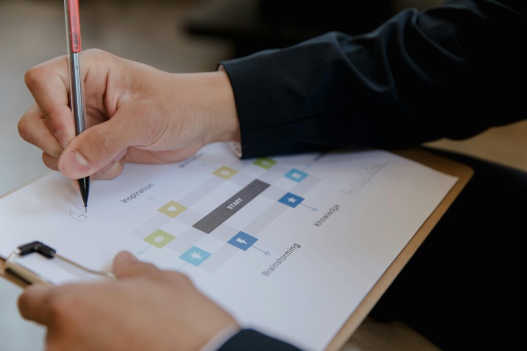 Close-up of a person writing on a business strategy document with a pen.