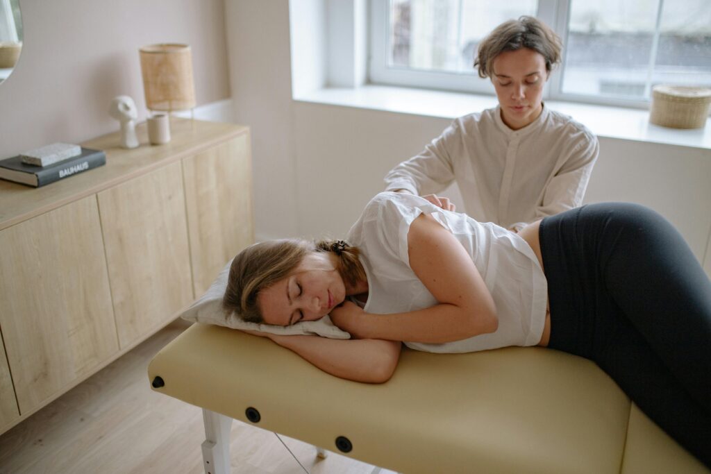 A woman receives a therapeutic massage from a specialist indoors.